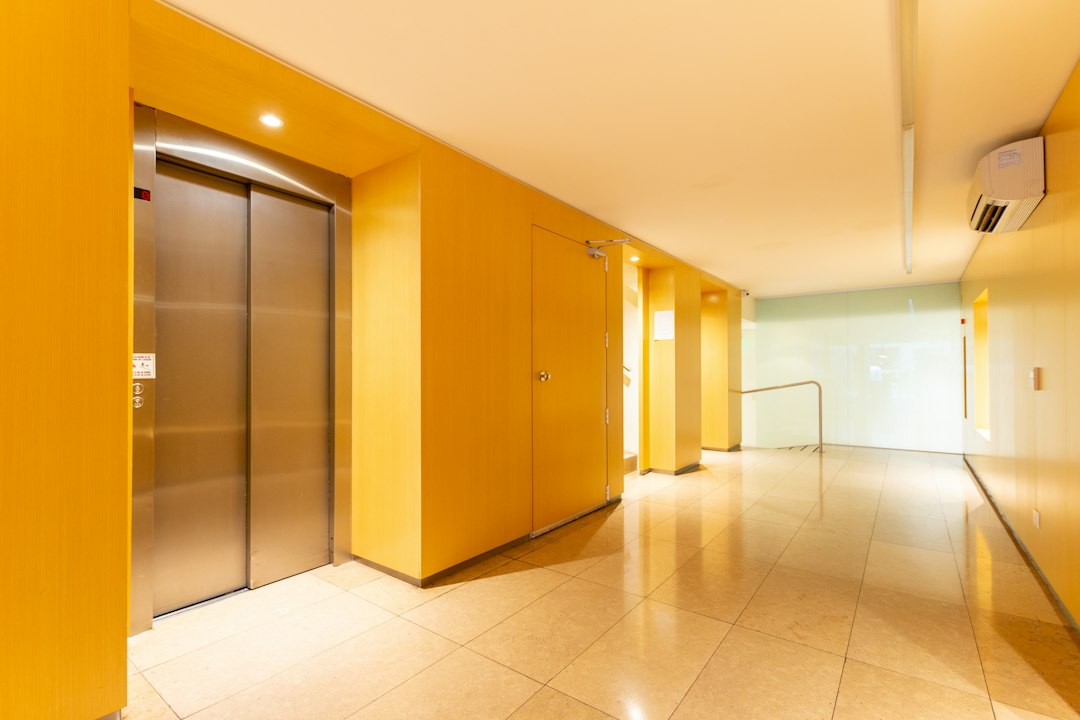 Elevator doors in a brightly lit yellow corridor