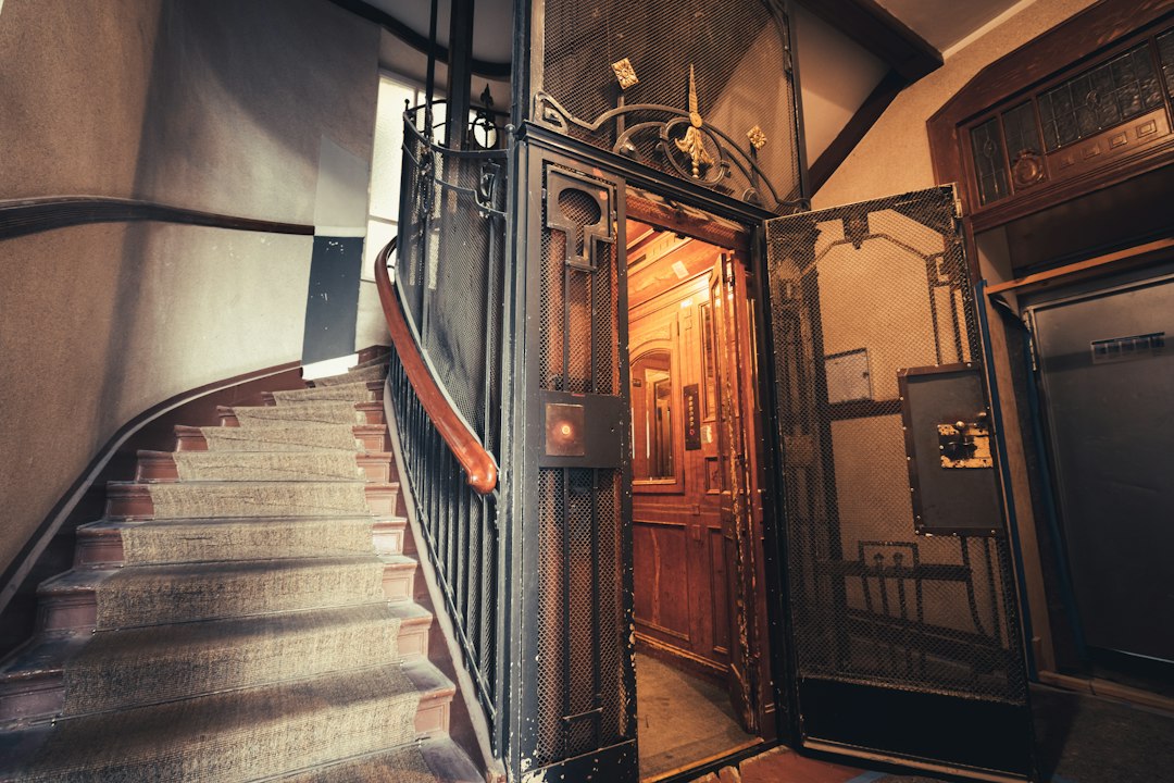 Staircase with an ornate metal railing beside a wooden doorway