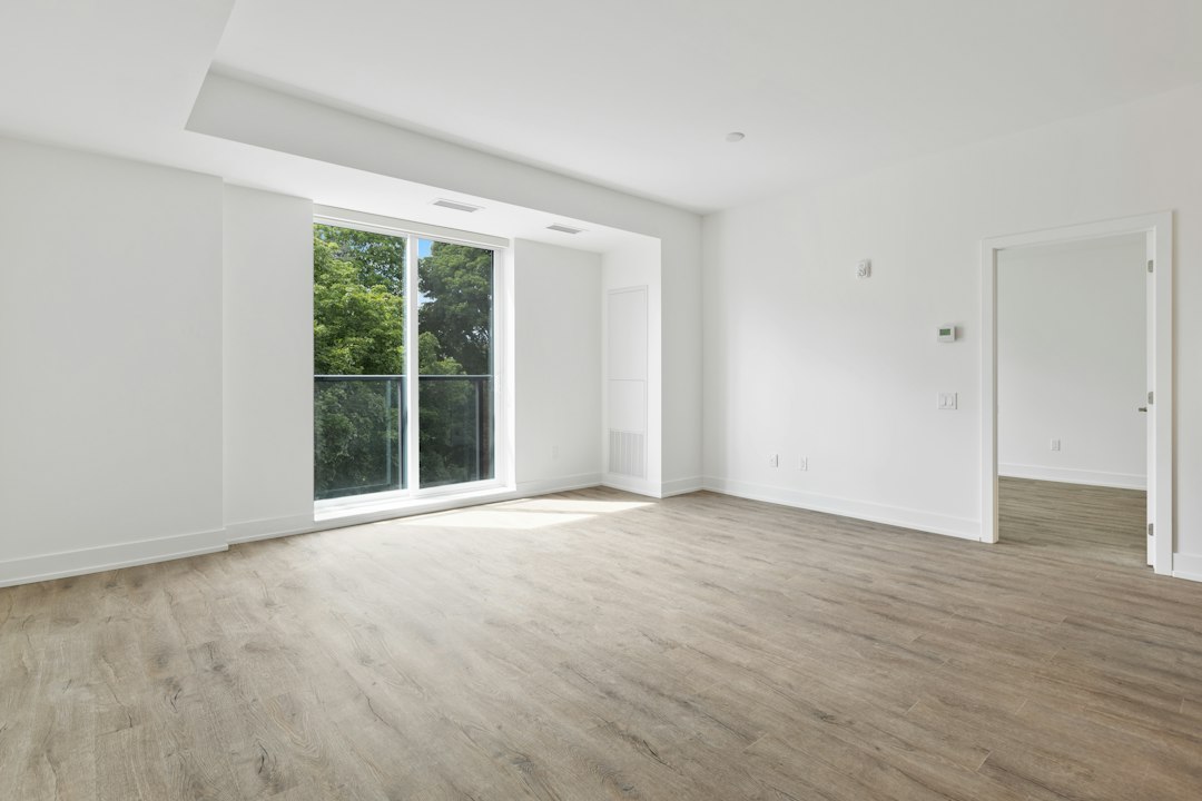Unfurnished white room with a large sliding glass door