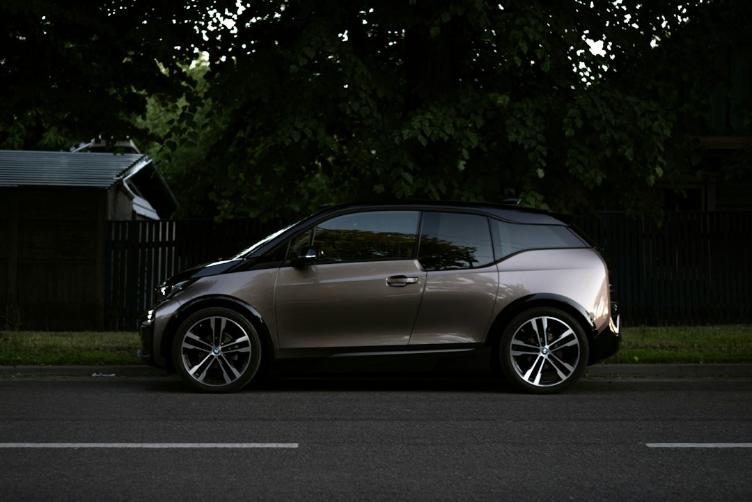 Silver compact hatchback parked in profile beneath trees