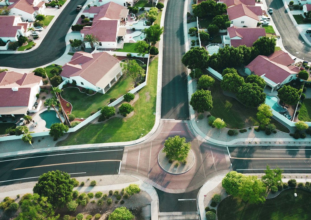 Aerial view of a residential neighborhood with detached houses, lawns, and a circular intersection