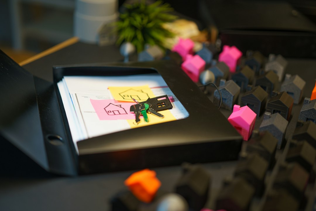 Keys and house-shaped models beside paperwork in a tray
