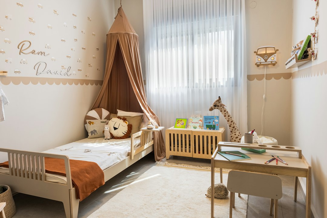 Child's room with small beds, a desk and a fabric canopy
