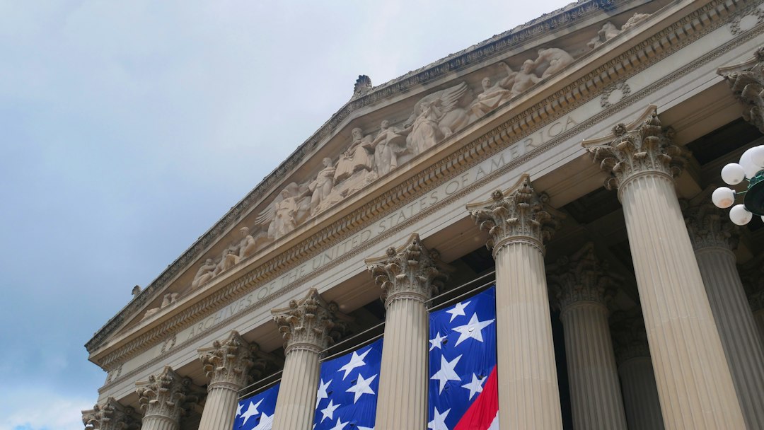 A classical columned facade decorated with a large American flag banner.
