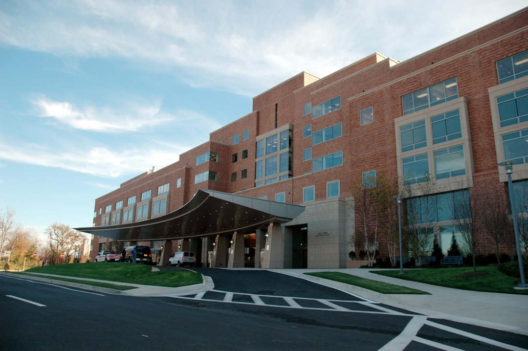 A brick medical building with a covered entrance beside a roadway.