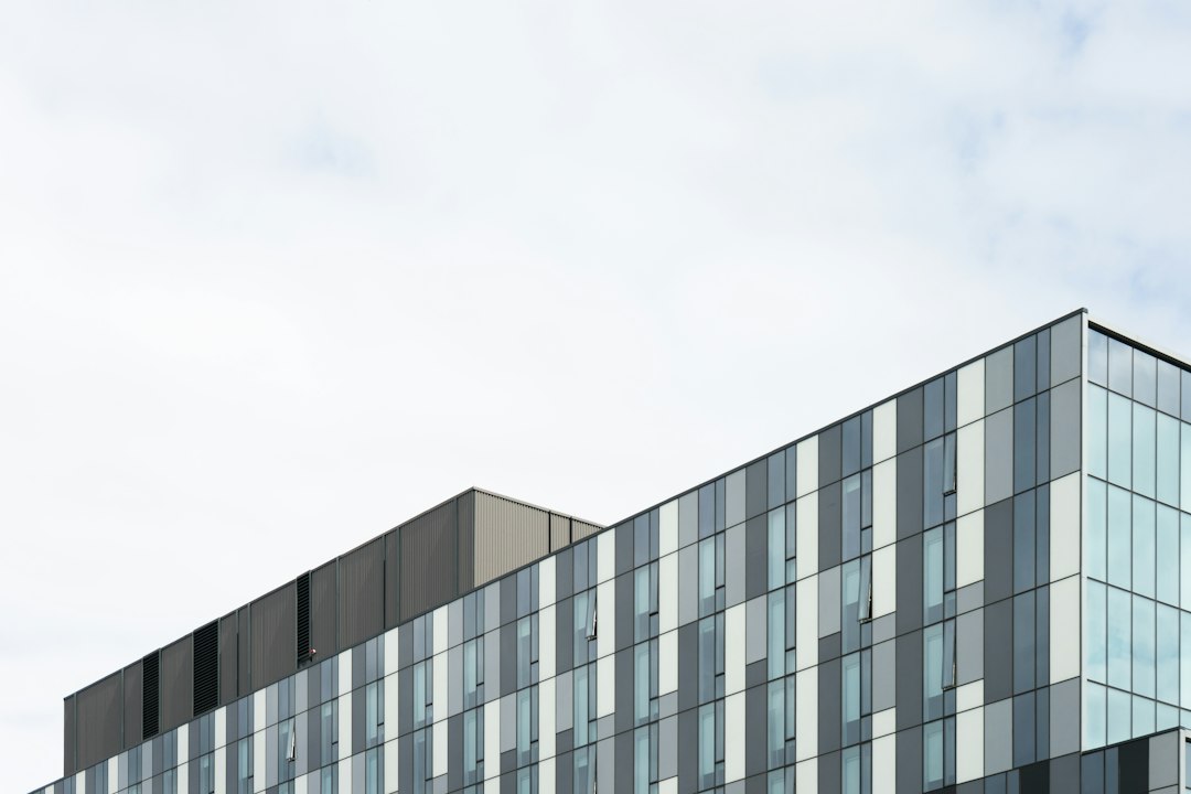 A modern building facade with tall windows and gray panels.