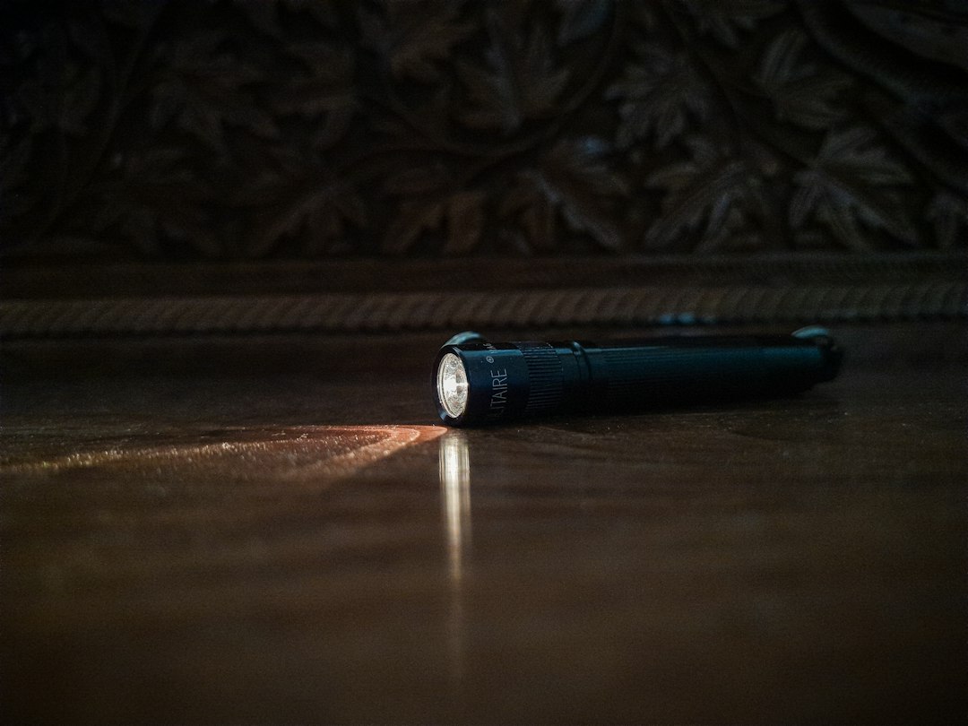 A flashlight casting a beam across a dark floor.