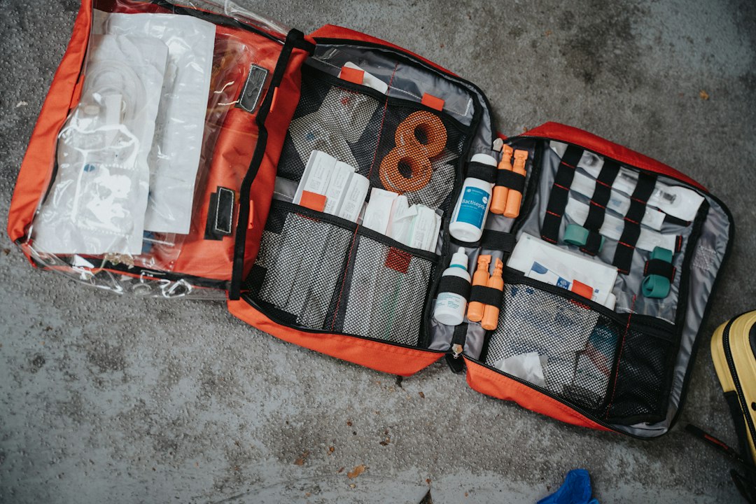 An open first aid bag with medical supplies organized in compartments.