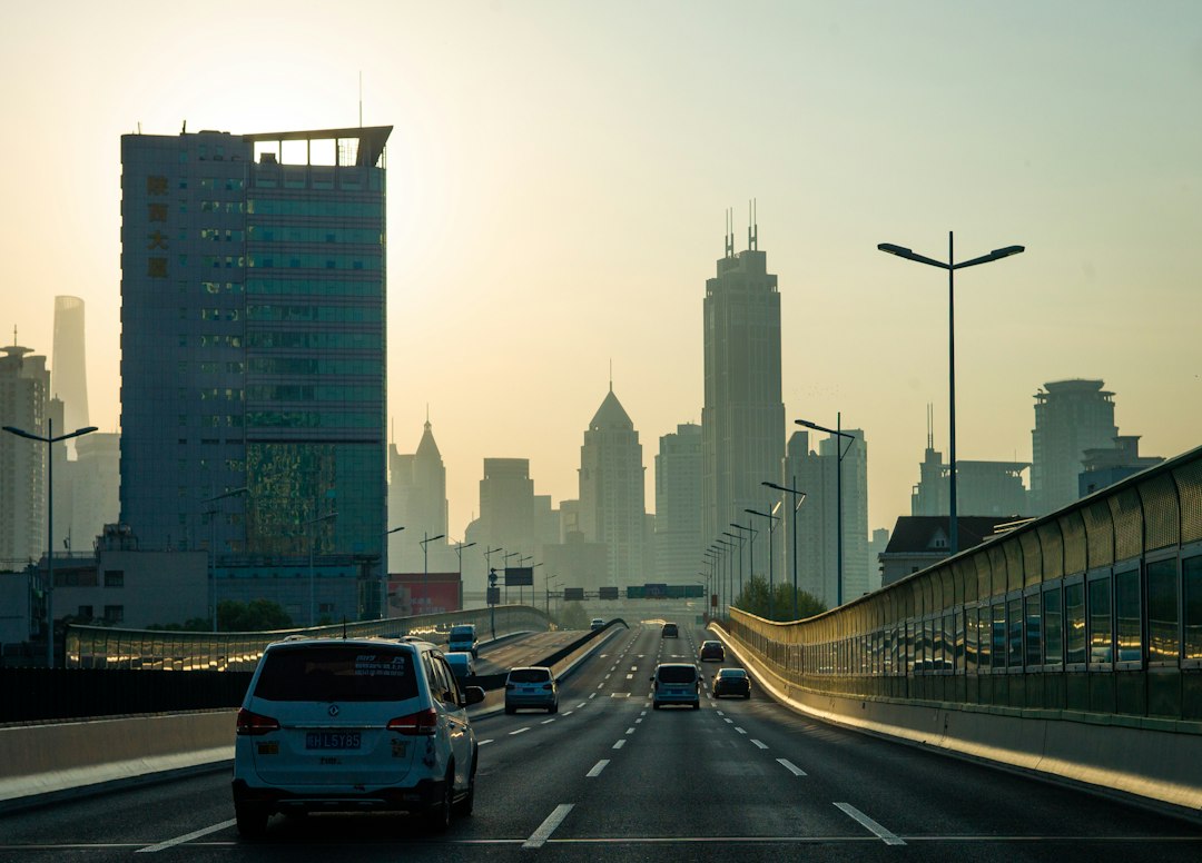 Vehicles on a divided highway with a city skyline in the distance.