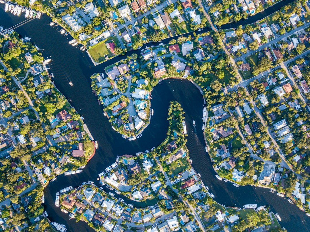 Aerial view of homes and boats along a winding waterfront canal
