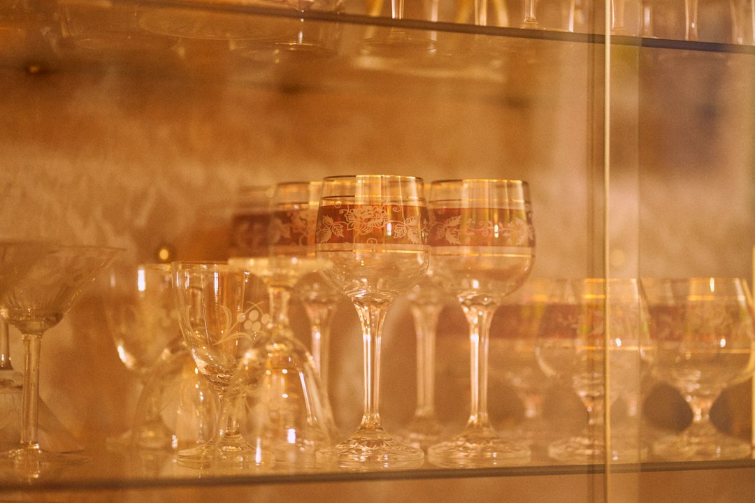 Rows of delicate stemmed glasses lit with warm light.