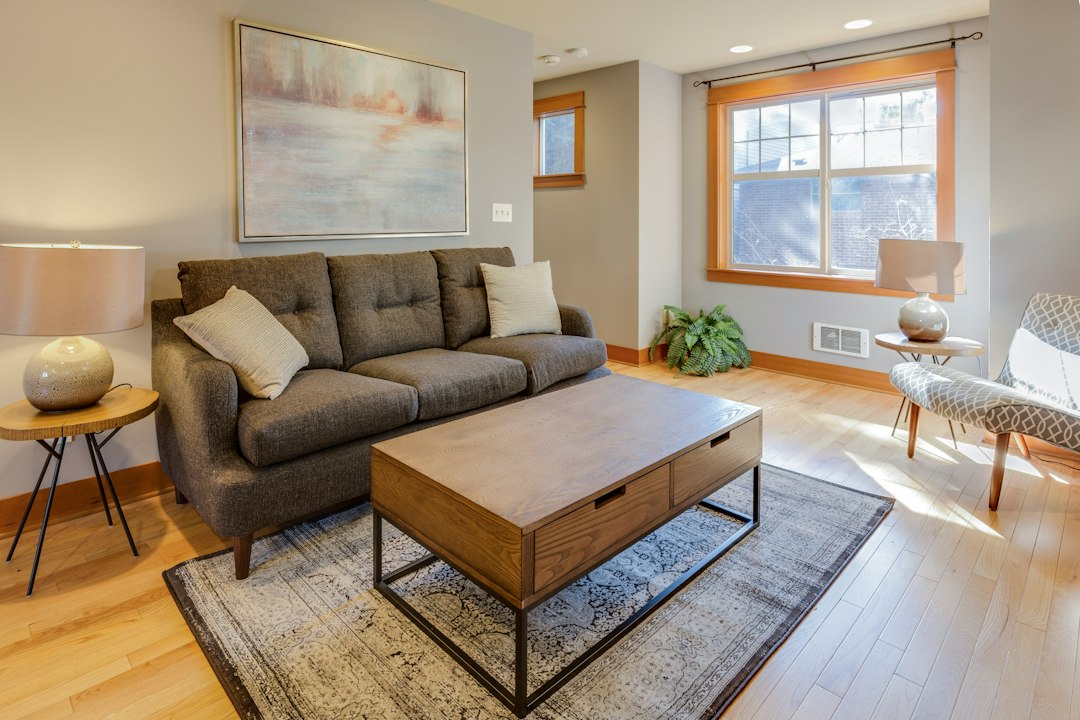 Gray sofa and wooden coffee table beside a sunlit window.