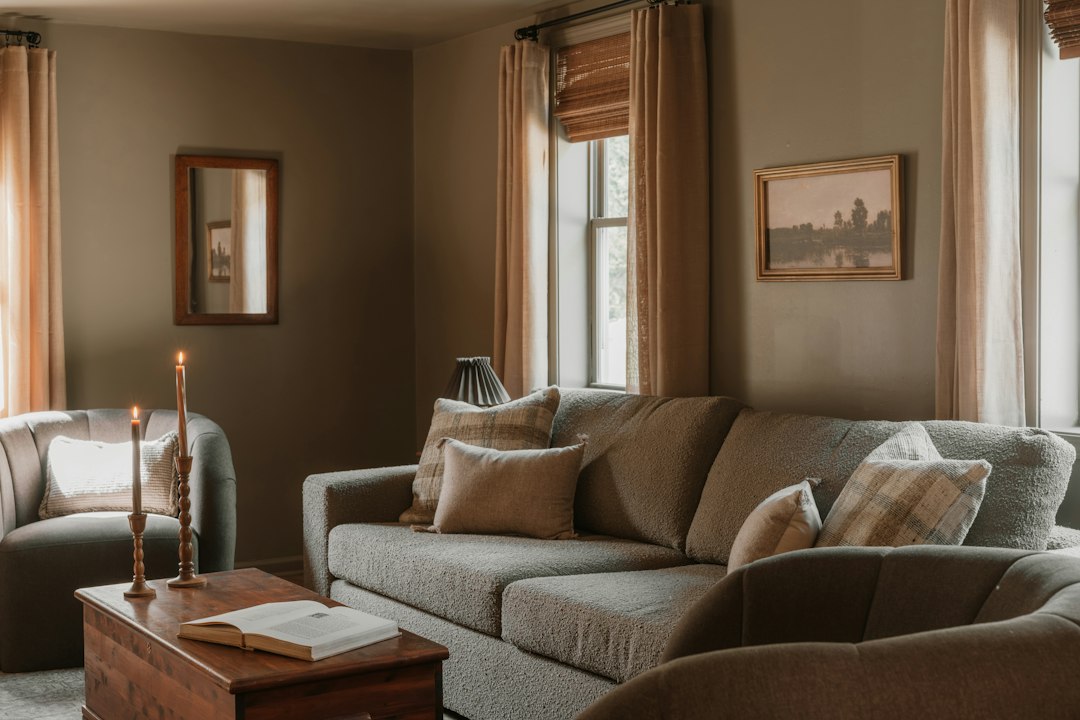 Soft gray sofa and armchair in a warmly lit room.