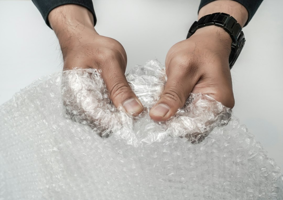 Hands holding a sheet of clear bubble wrap