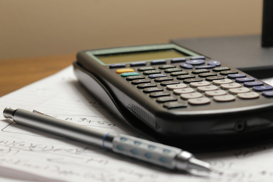 Calculator and pen on handwritten calculation notes