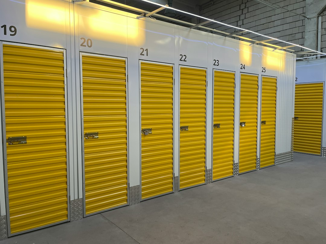 Numbered yellow roll-up storage doors inside a brightly lit facility.