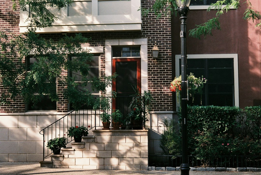 Front steps and a dark red door on a brick townhouse.