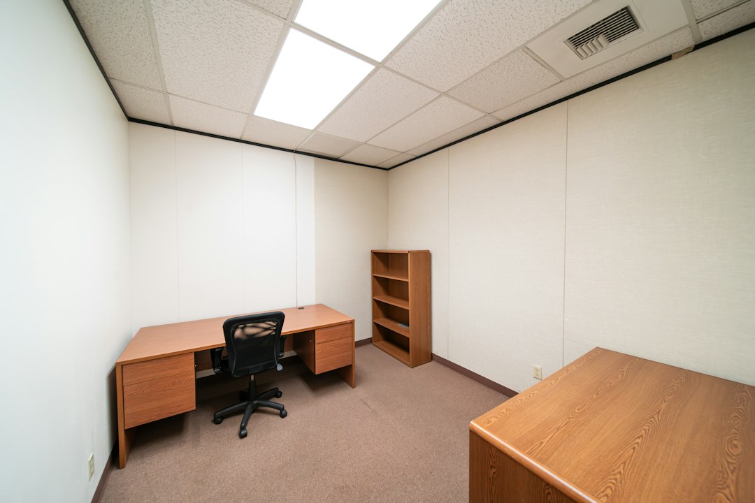 Small office with a desk, empty bookcase and rolling chair