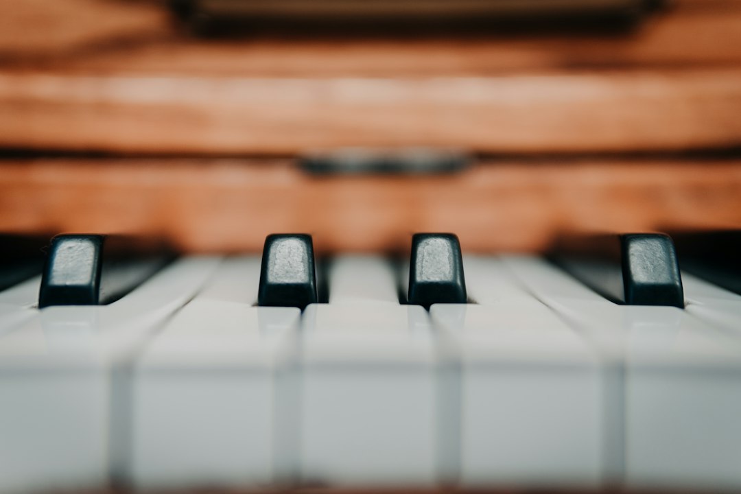 Close-up of worn white and black keys on a wooden piano.