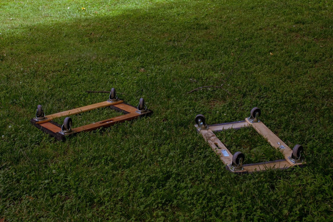 Two wheeled furniture dollies resting on grass