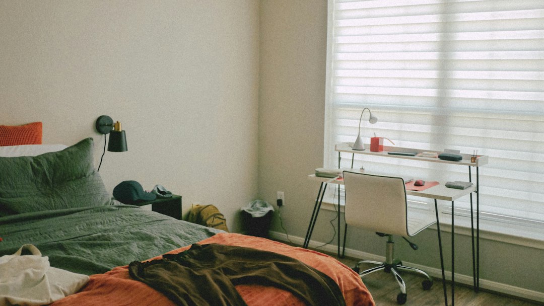 Compact bedroom with a bed and a desk beneath a window