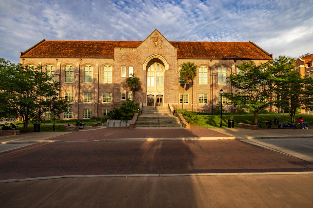 Stone university building with a central arched doorway in warm evening light