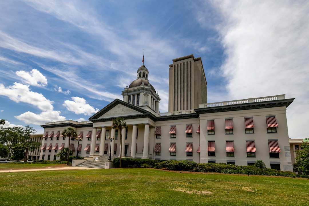 Historic Florida Capitol in Tallahassee beneath a cloudy sky, with the newer capitol tower behind it